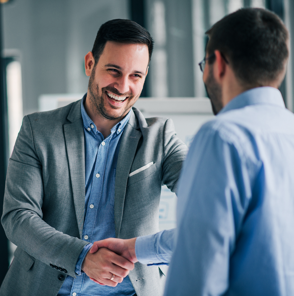 Portrait of cheerful young manager handshake with new employee.