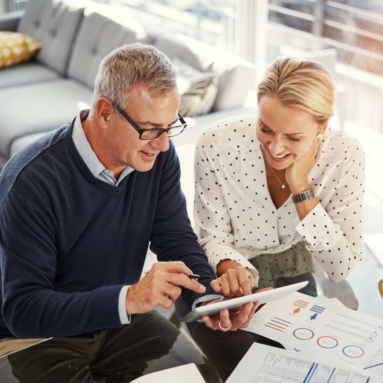 Shot of a mature couple using a digital tablet while going through paperwork at home